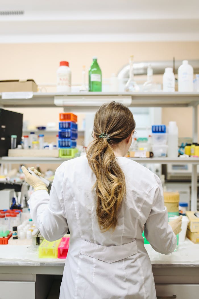 Back view of a female scientist working in a modern laboratory setting with various equipment.